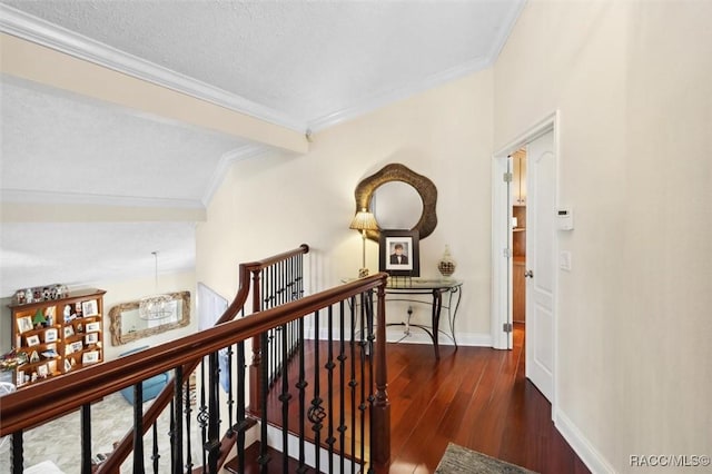 hall with a textured ceiling, dark hardwood / wood-style floors, and crown molding