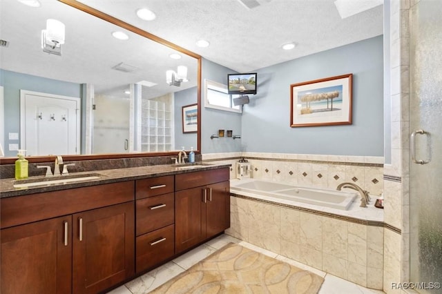 bathroom featuring tile patterned floors, plus walk in shower, vanity, and a textured ceiling