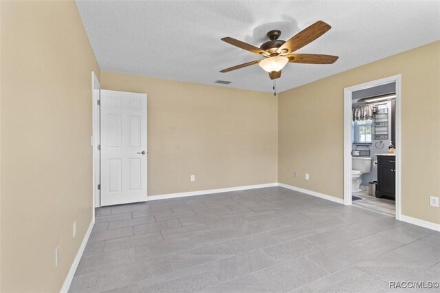 spare room featuring a textured ceiling and ceiling fan