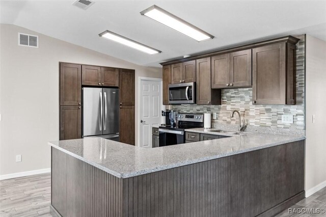 kitchen with tasteful backsplash, stainless steel electric range oven, light stone countertops, and sink