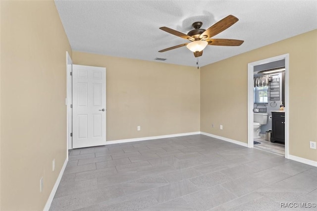 unfurnished room featuring ceiling fan and a textured ceiling