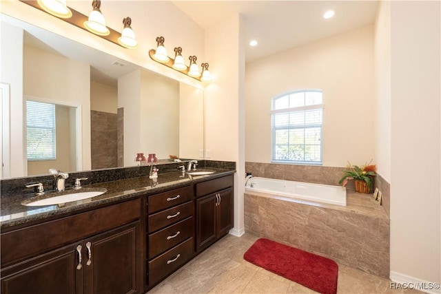 full bath featuring double vanity, a garden tub, tile patterned flooring, and a sink