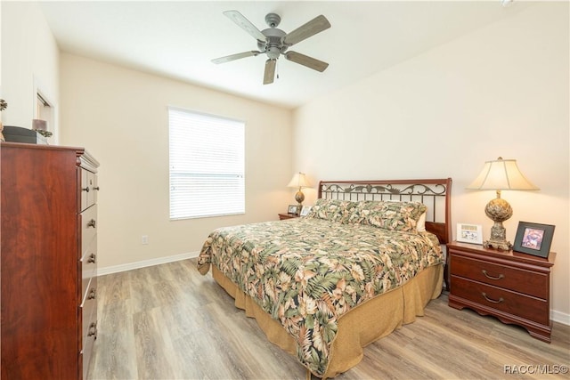 bedroom with light wood-type flooring, a ceiling fan, and baseboards