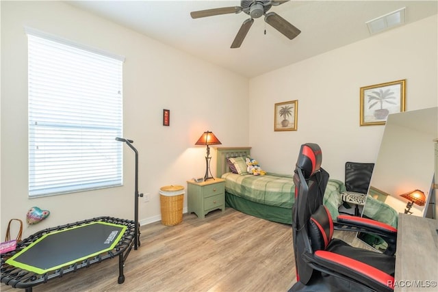 bedroom featuring ceiling fan, light wood finished floors, and visible vents