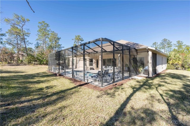 back of property with a patio, a lawn, a lanai, and an outdoor pool