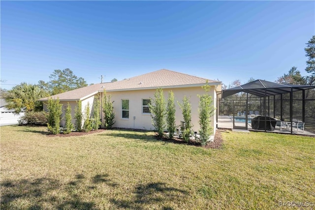 back of house with an outdoor pool, glass enclosure, a yard, and stucco siding