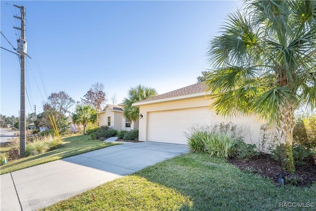 view of front facade featuring a garage, a front yard, concrete driveway, and stucco siding