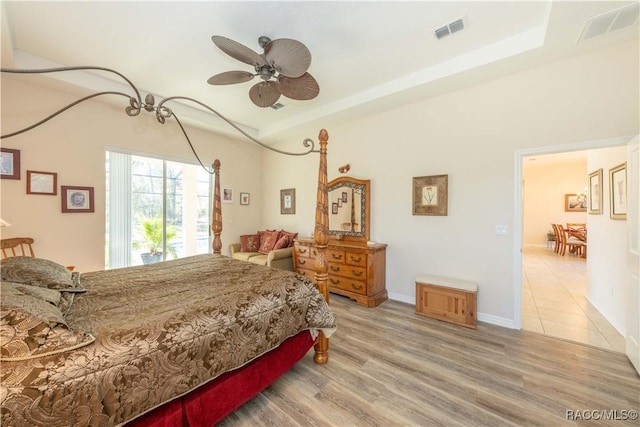 bedroom with light wood-type flooring, baseboards, visible vents, and a ceiling fan