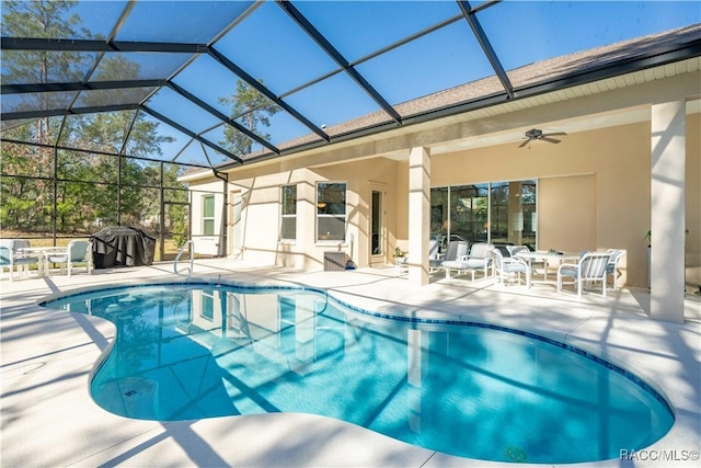 pool with a ceiling fan, glass enclosure, and a patio area