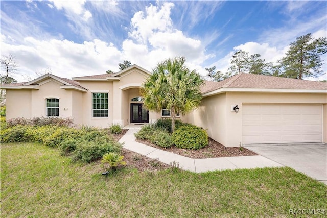 view of front of property featuring concrete driveway, a front lawn, an attached garage, and stucco siding