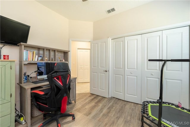 office area with light wood-style flooring and visible vents