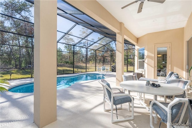 exterior space featuring glass enclosure, ceiling fan, outdoor dining area, and a patio