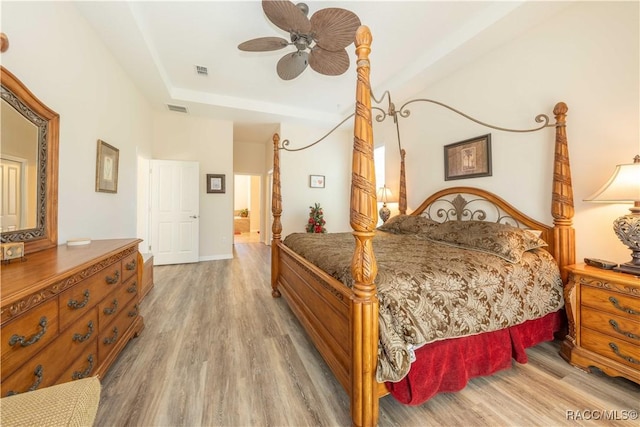 bedroom featuring light wood-type flooring, ceiling fan, visible vents, and baseboards