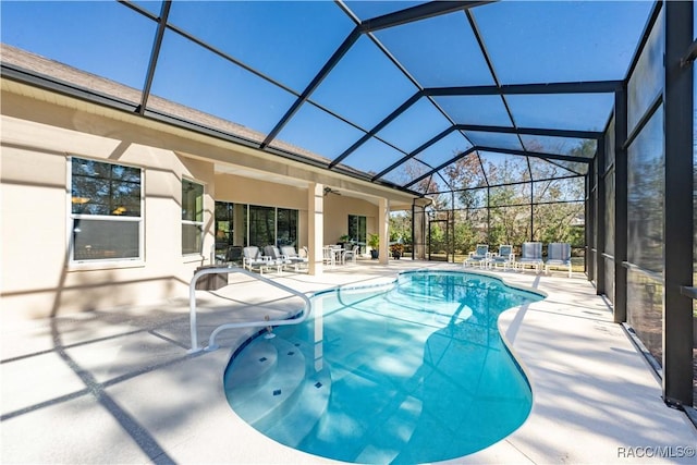 pool with glass enclosure, a patio, and ceiling fan