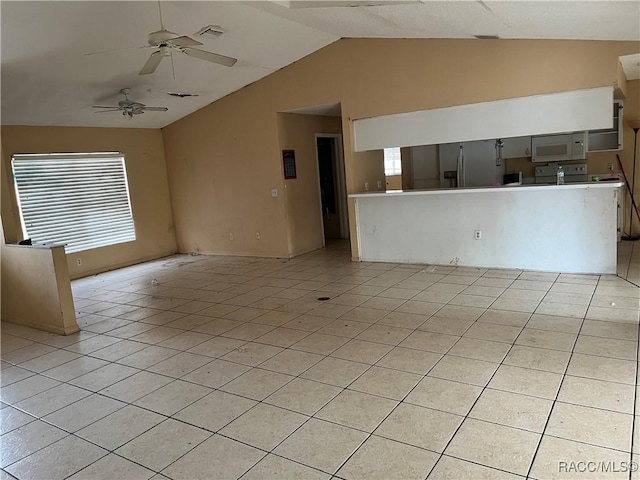 unfurnished living room featuring ceiling fan, lofted ceiling, and light tile patterned floors