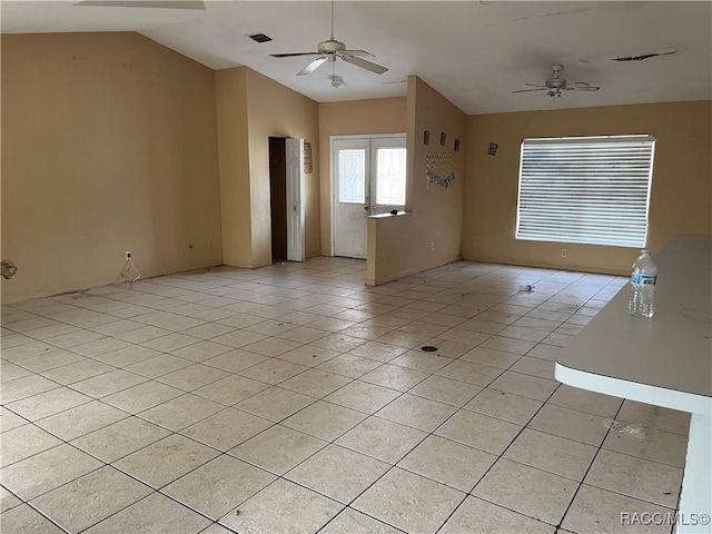 tiled spare room with french doors, vaulted ceiling, and ceiling fan