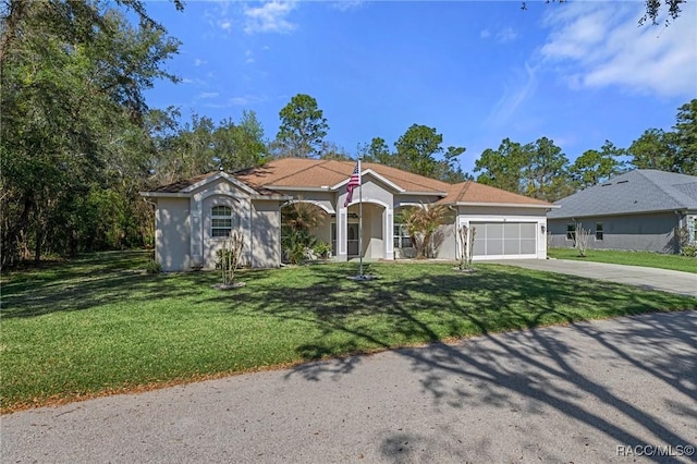 mediterranean / spanish house with an attached garage, a front lawn, concrete driveway, and stucco siding