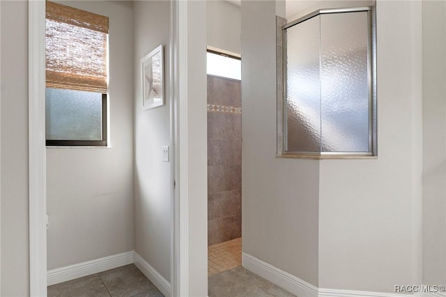 bathroom with tile patterned flooring, plenty of natural light, and tiled shower