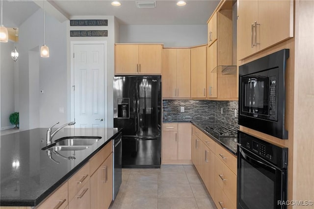 kitchen with sink, light brown cabinets, dark stone counters, and black appliances