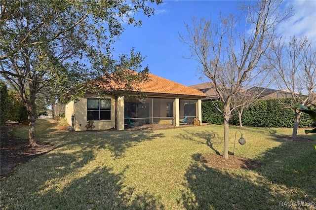 rear view of house with a yard and a sunroom