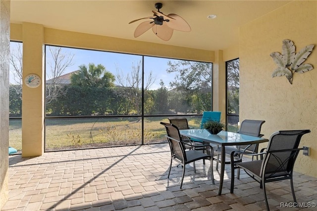 sunroom / solarium featuring plenty of natural light and ceiling fan