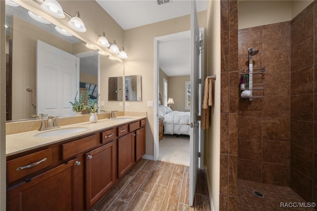 bathroom featuring tiled shower and vanity