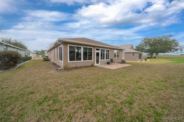 back of house with a yard and a patio