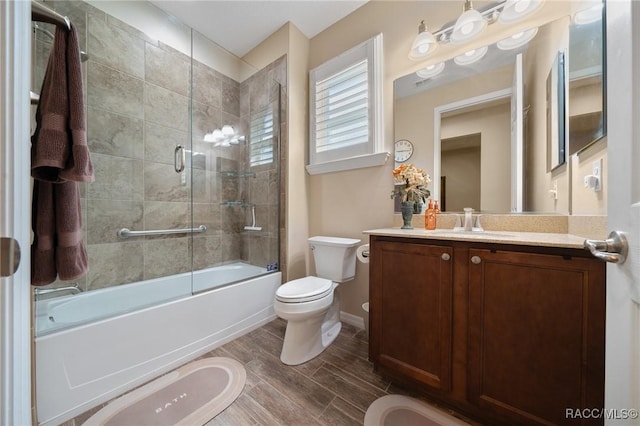 full bathroom with vanity, combined bath / shower with glass door, and toilet