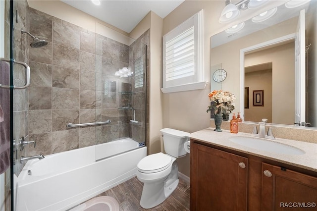 full bathroom with vanity, wood-type flooring, combined bath / shower with glass door, and toilet