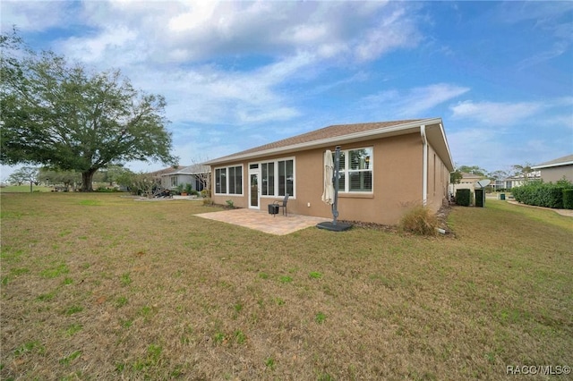 rear view of property featuring a patio and a lawn