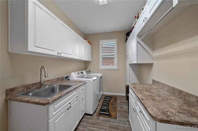 clothes washing area with cabinets, sink, and washing machine and dryer