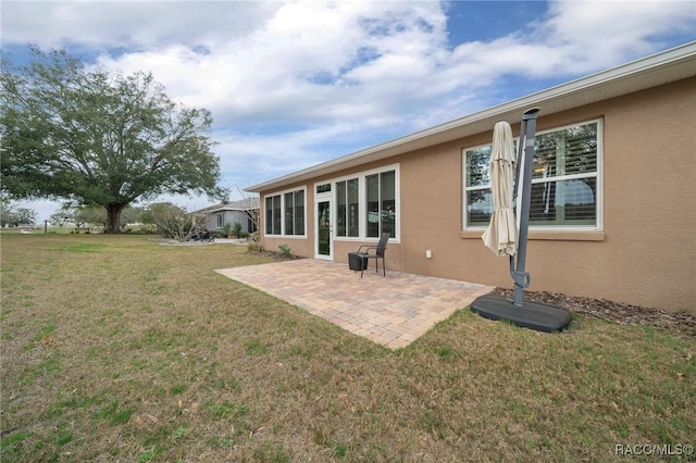 rear view of house with a patio and a yard