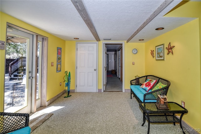 sitting room with carpet, a textured ceiling, and baseboards