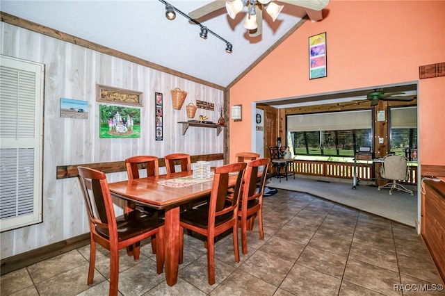 dining space featuring ceiling fan, dark tile patterned floors, lofted ceiling with beams, and baseboards