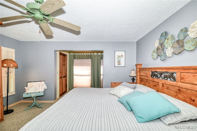 bedroom featuring a ceiling fan, a textured ceiling, baseboards, and carpet flooring