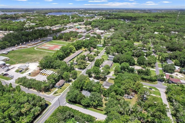 birds eye view of property with a water view and a wooded view