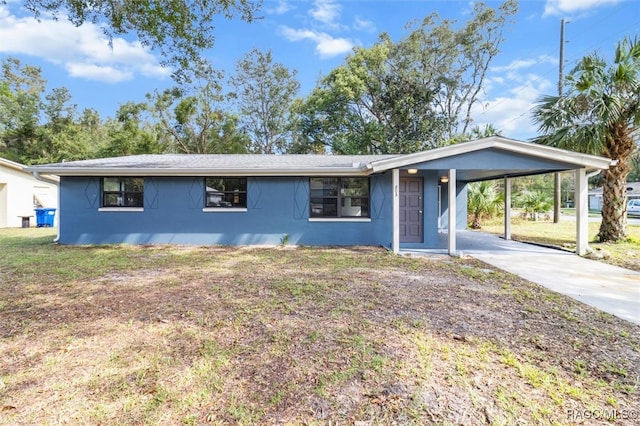 ranch-style house featuring concrete driveway, an attached carport, a front lawn, and stucco siding