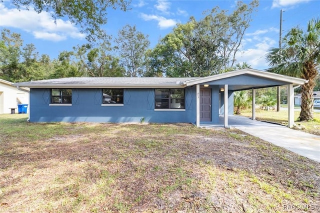 803 NE 5th Ave, Crystal River, FL 34428 - view of front of property with concrete driveway, an attached carport, stucco siding, and a front yard