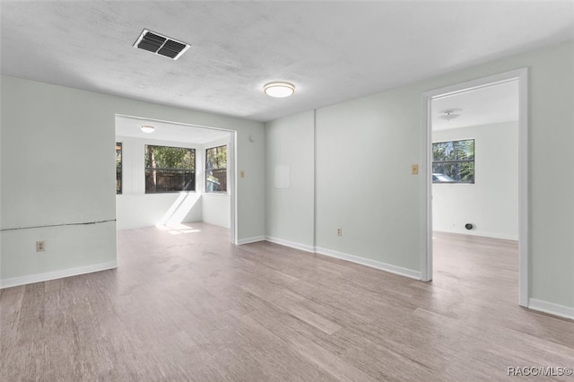 unfurnished room featuring a textured ceiling and light hardwood / wood-style floors