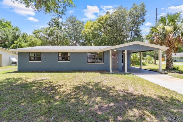 803 NE 5th Ave, Crystal River, FL 34428 - view of front of home with a front lawn, stucco siding, concrete driveway, and an attached carport