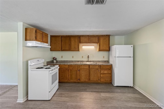 kitchen with white appliances, light hardwood / wood-style floors, and sink