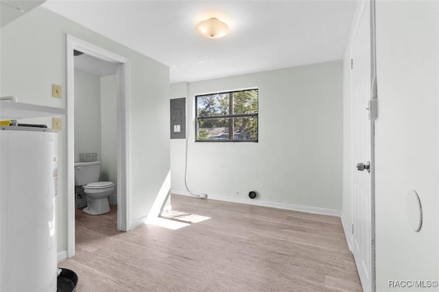 bathroom with wood-type flooring, electric panel, gas water heater, and toilet