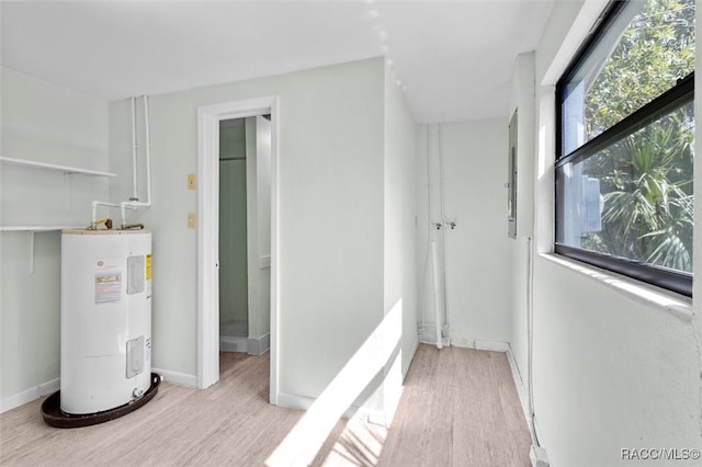 interior space with electric water heater and light hardwood / wood-style flooring