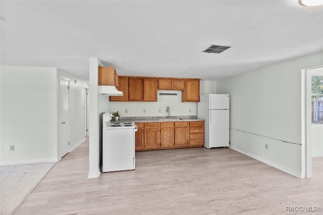 kitchen with light wood-type flooring, white appliances, and sink