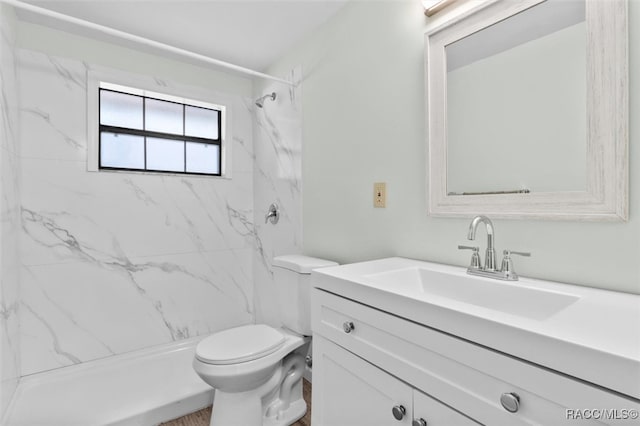 bathroom featuring vanity, toilet, and tiled shower