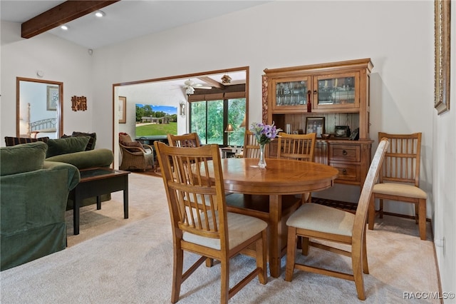 dining room featuring ceiling fan, beam ceiling, and light carpet