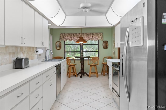 kitchen with decorative light fixtures, sink, white cabinetry, and stainless steel appliances