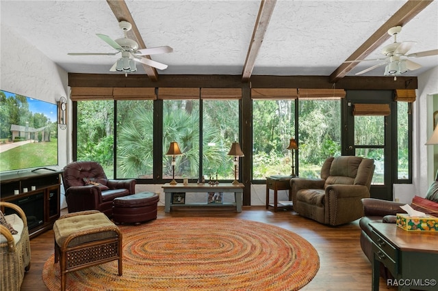 sunroom with ceiling fan and beamed ceiling