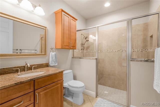 bathroom with vanity, toilet, tile patterned floors, and a shower with shower door