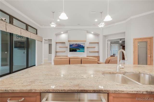 kitchen featuring hanging light fixtures, light stone countertops, ornamental molding, ceiling fan, and sink